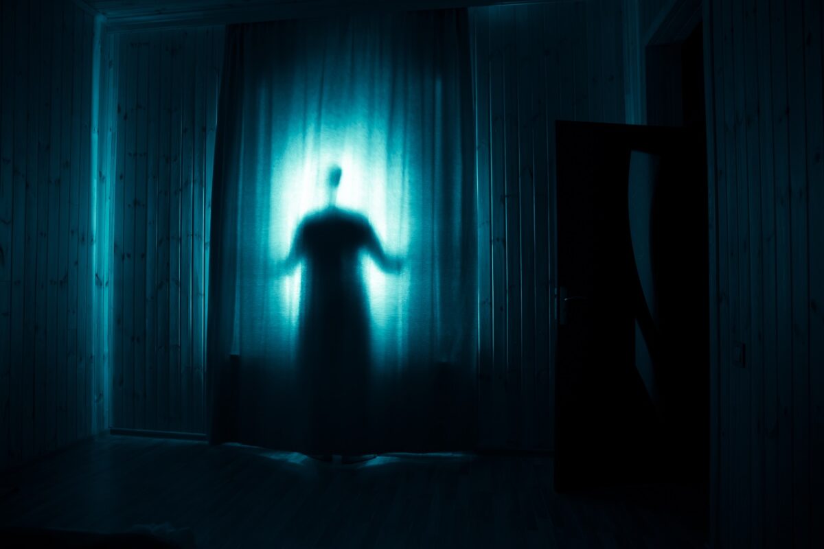 Horror,silhouette,in,window,with,curtain,inside,bedroom,at,night.
