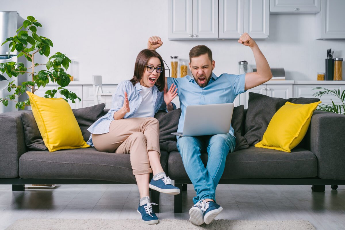 Young,excited,overjoyed,couple,of,football,fans,looking,at,their
