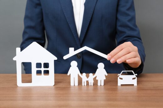 Woman,with,cutout,paper,family,,house,and,car,at,table,