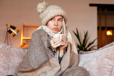 Frozen.,sad,woman,sit,on,couch,at,freezing,cooled,house
