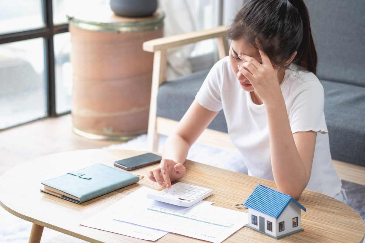 Young,asian,woman,sitting,and,calculating,expenses,and,mortgage,with