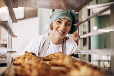 Female,baker,at,the,kitchen,holding,croissant