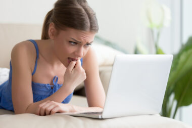 Worried,young,woman,using,laptop,,teenager,feeling,nervous,passing,online