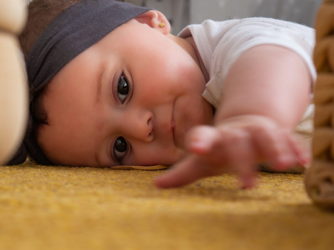 Baby,on,the,floor,learning,to,pick,up,objects,,montessori
