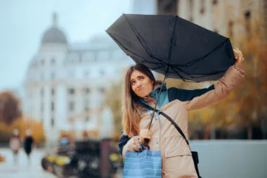 Stressed,woman,walking,in,the,rain,with,broken,umbrella,girl
