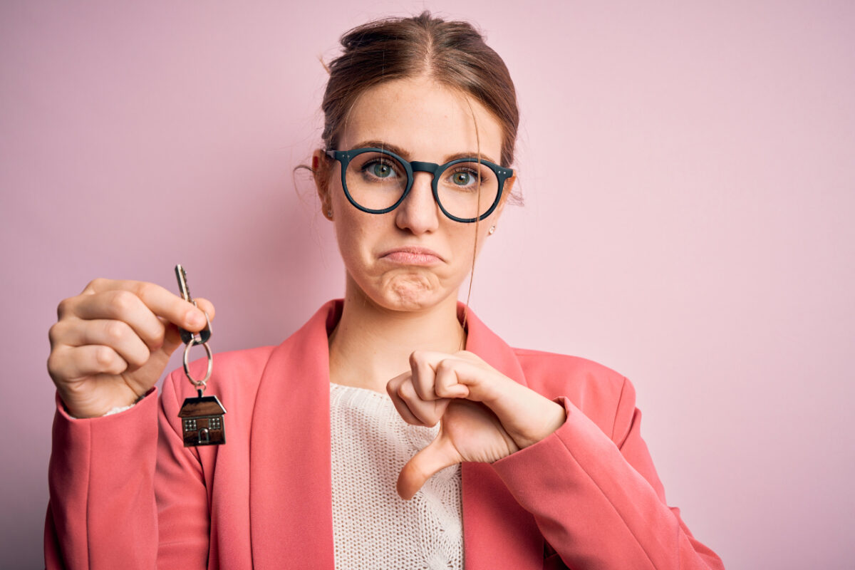 Young,beautiful,redhead,house,agent,woman,holding,home,key,over