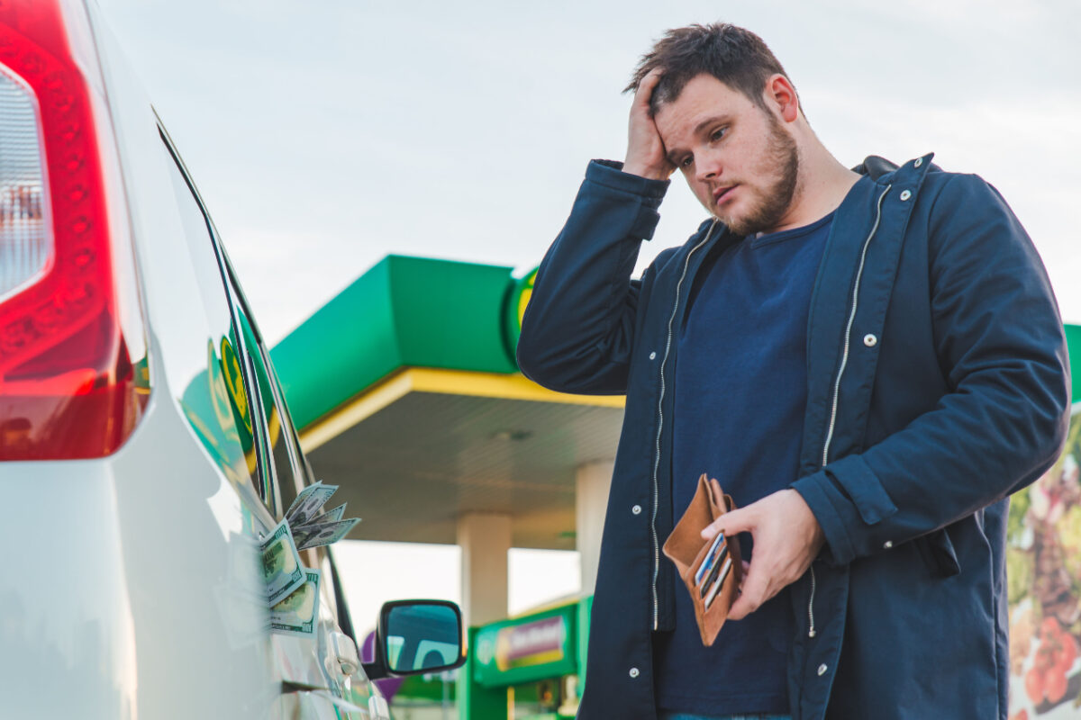 Man,with,sad,view,and,empty,wallet,at,gas,station.