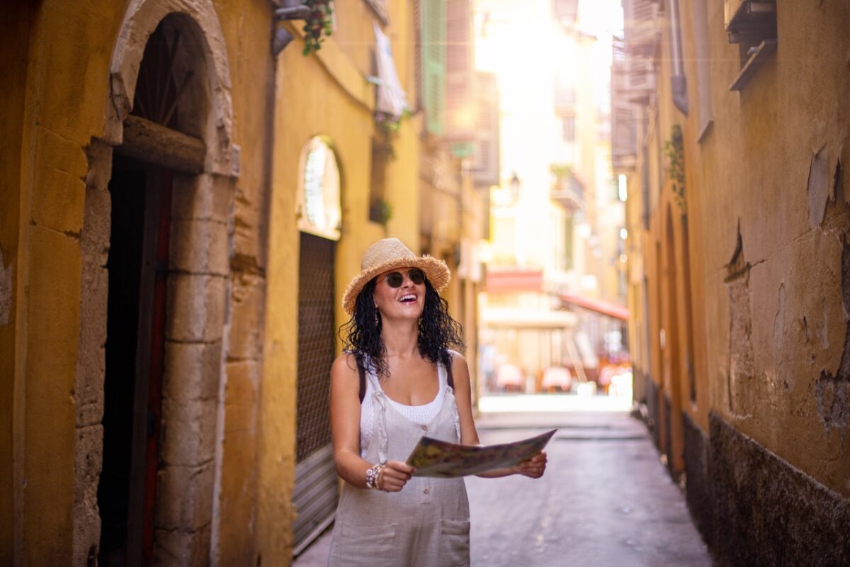 A,tourist,woman,walking,at,the,narrow,streets,of,nice