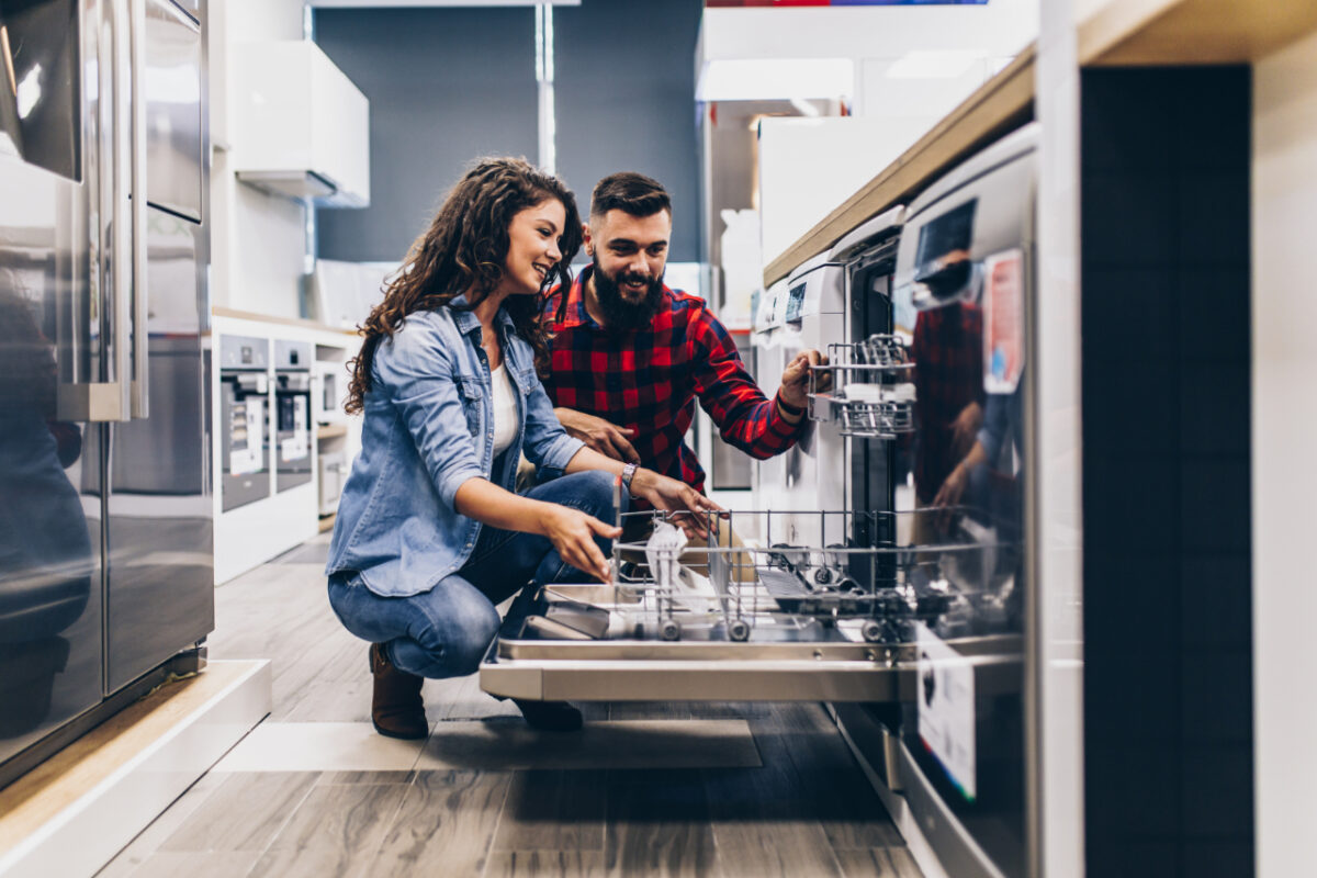 Beautiful,and,happy,young,couple,buying,dishwasher,in,modern,appliances