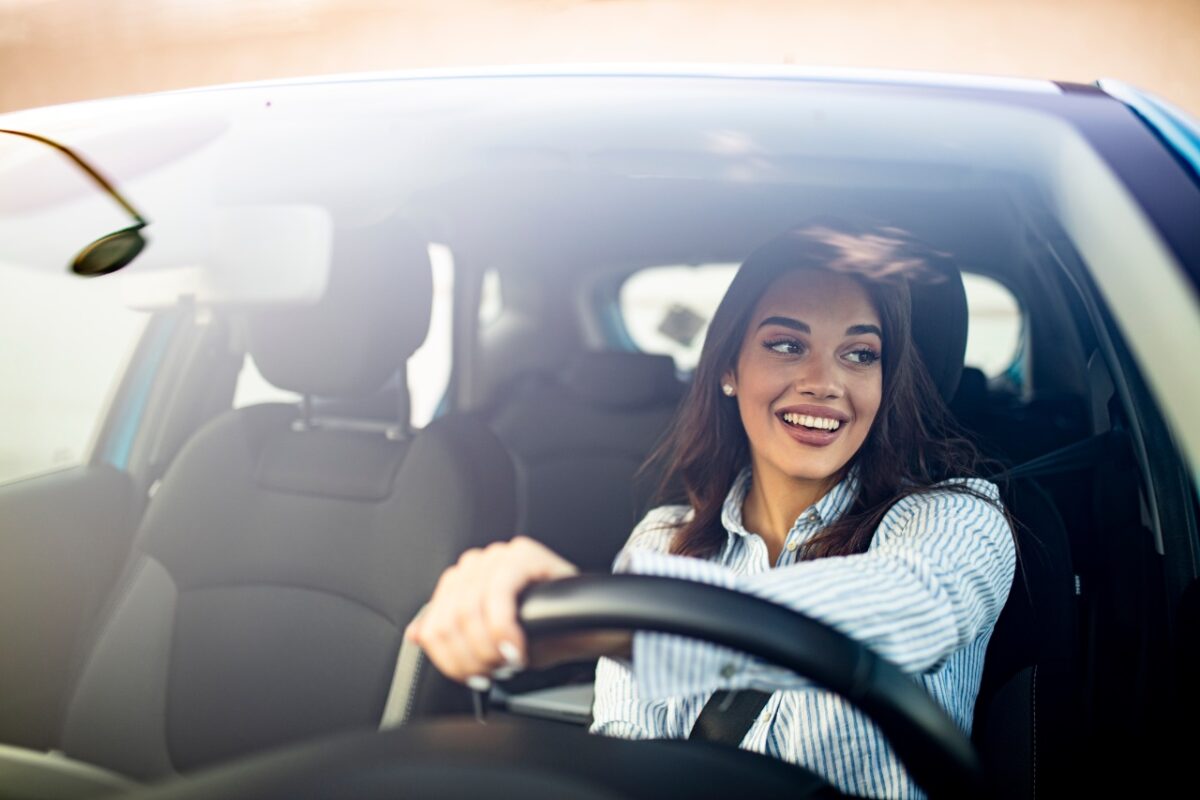 Happy,woman,driving,a,car,and,smiling.,cute,young,success