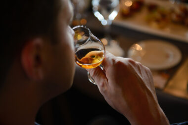 Man,tasting,cognac,holding,glass,close,to,nose,smelling,the