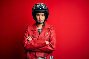 Young,beautiful,brunette,motorcyclist,woman,wearing,motorcycle,helmet,and,red