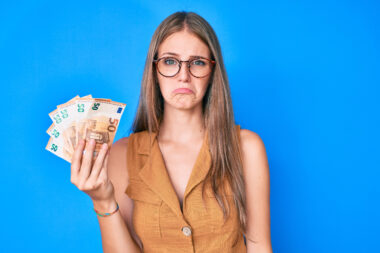 Young,blonde,woman,holding,euro,banknotes,depressed,and,worry,for