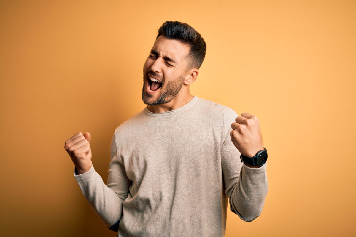 Young,handsome,man,wearing,casual,sweater,standing,over,isolated,yellow