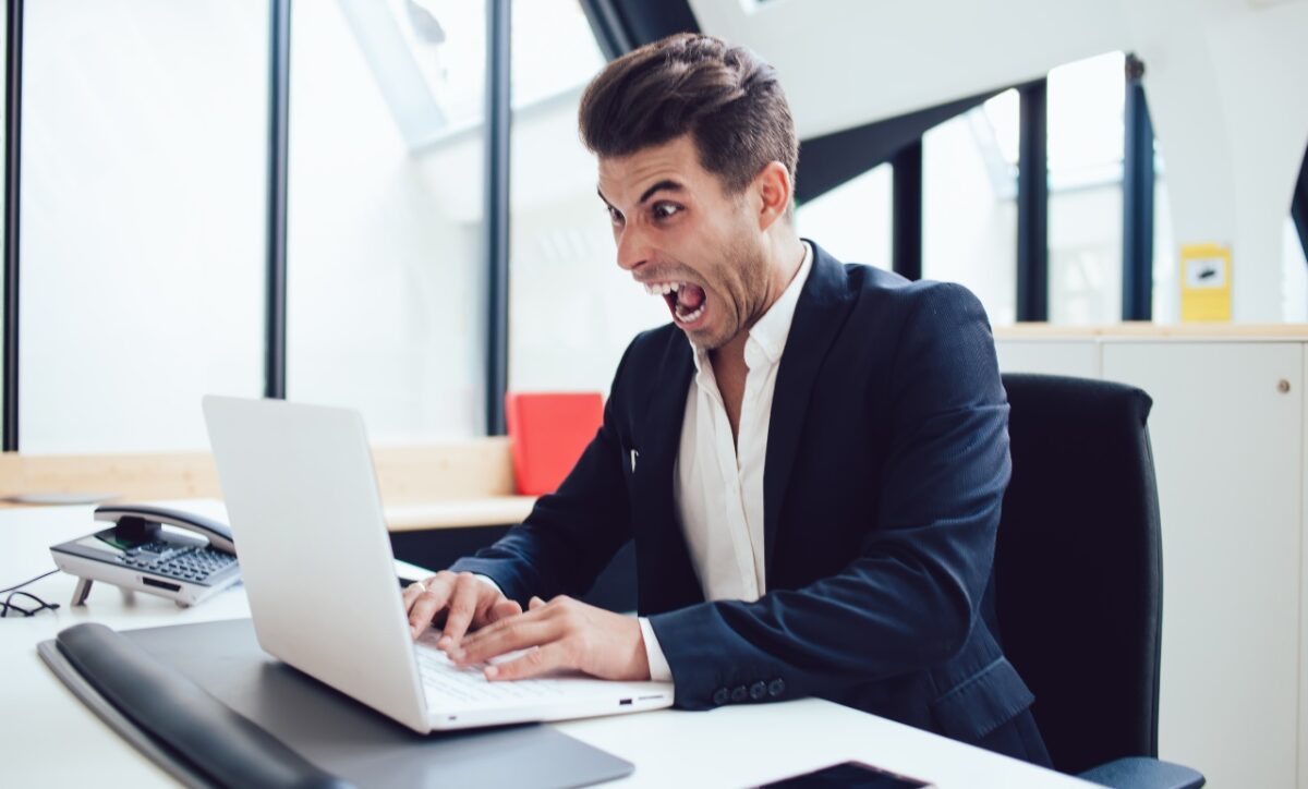 Angry,caucasian,businessman,in,formal,wear,furious,about,problems,browsing