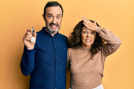 Middle,age,hispanic,couple,holding,keys,of,new,home,stressed