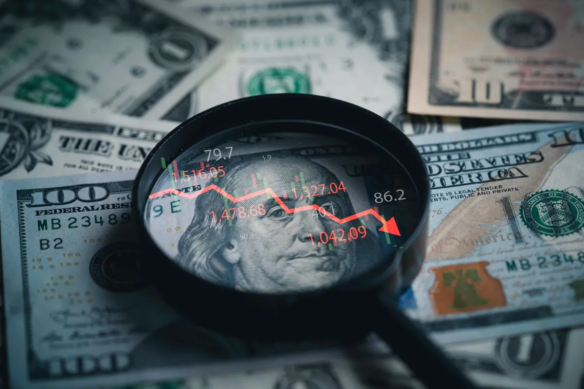 Red,down,arrow,inside,of,magnifier,glass,and,usd,dollar