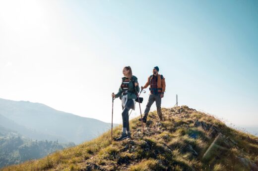 Couple,hiking,on,a,scenic,mountain,trail,with,backpacks,and