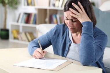 Sad,middle,age,woman,signing,document,complaining,sitting,in,the