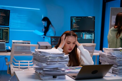 Frustrated,young,woman,clutches,her,head,in,stress,while,surrounded