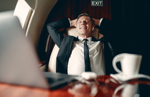 Senior,businessman,in,suit,flying,in,private,jet,and,listening