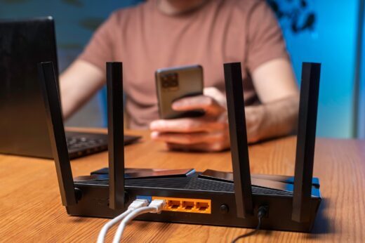 Modern,wifi,router,with,multiple,antennas,on,wooden,desk,,man