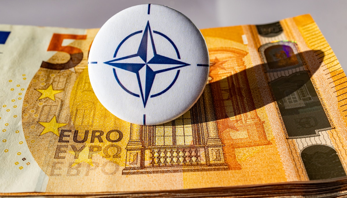 Pièce de monnaie de l'OTAN sur des billets en euros.