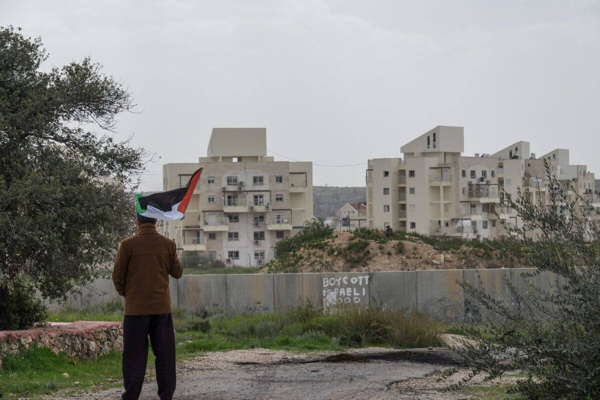 A,palestinian,protester,stands,near,the,west,bank,barrier,holding