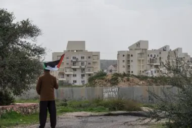 A,palestinian,protester,stands,near,the,west,bank,barrier,holding
