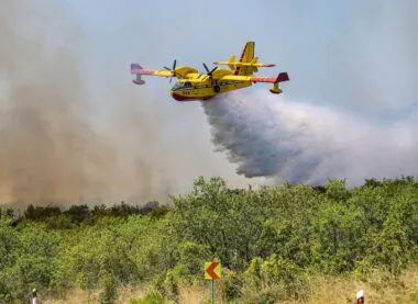 An,aerial,firefighting,plane,releasing,water,over,a,forest,fire,