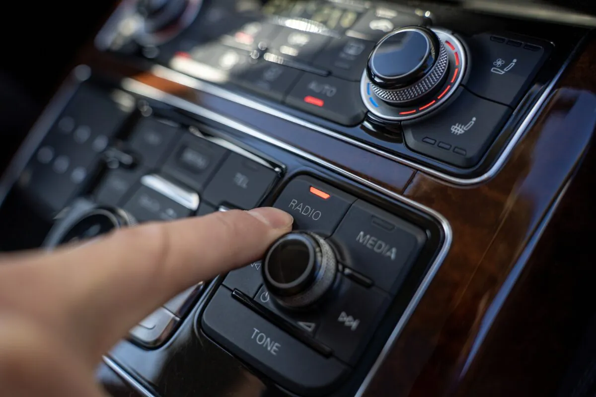 Driver,finger,pressing,radio,button,on,car,multimedia,control,panel