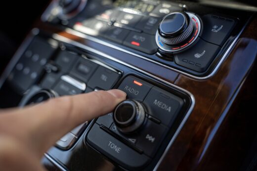 Driver,finger,pressing,radio,button,on,car,multimedia,control,panel
